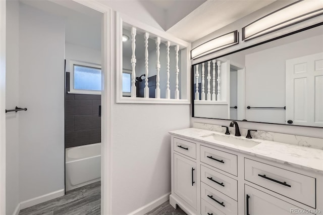 bathroom featuring vanity, tiled shower / bath combo, and hardwood / wood-style flooring