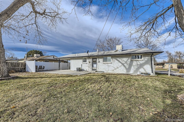 back of house featuring a lawn, central AC unit, and a patio area