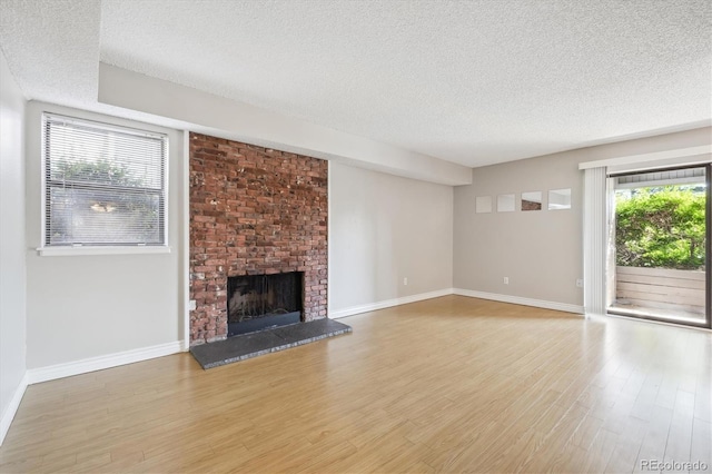 6490 S Dayton St Unit L02, Englewood, CO 80111 - unfurnished living room featuring a textured ceiling, wood finished floors, and a fireplace