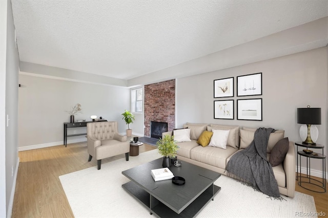 6490 S Dayton St Unit L02, Englewood, CO 80111 - living room with light wood-type flooring, a brick fireplace, and a textured ceiling