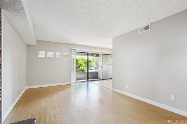 6490 S Dayton St Unit L02, Englewood, CO 80111 - empty room featuring a textured ceiling and wood finished floors