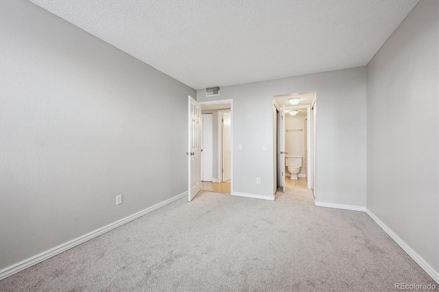 6490 S Dayton St Unit L02, Englewood, CO 80111 - unfurnished bedroom featuring carpet floors, a textured ceiling, and ensuite bathroom