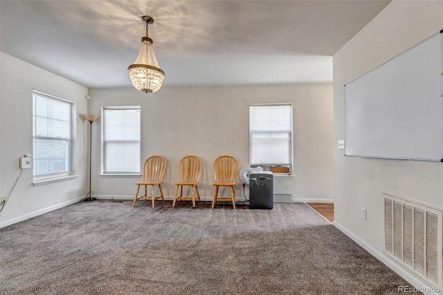 living area featuring a notable chandelier, carpet, visible vents, and baseboards