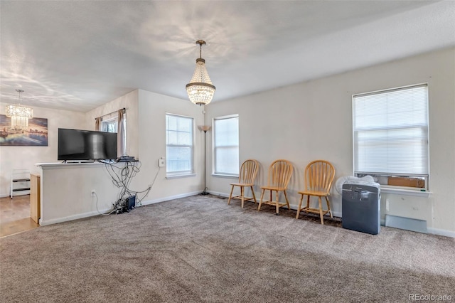 sitting room with an inviting chandelier, carpet, and baseboards