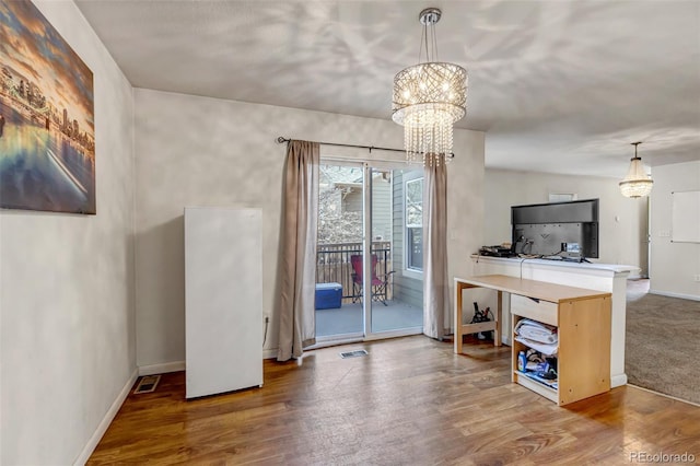 dining area featuring an inviting chandelier, baseboards, visible vents, and wood finished floors