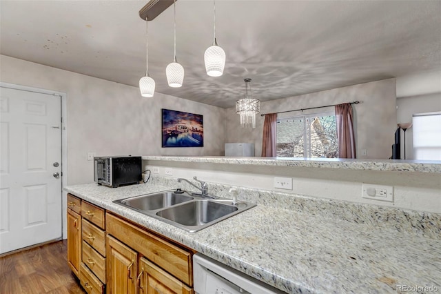 kitchen with dark wood-type flooring, light countertops, a sink, and decorative light fixtures