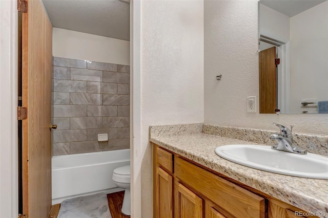 full bathroom featuring bathtub / shower combination, a textured wall, vanity, and toilet