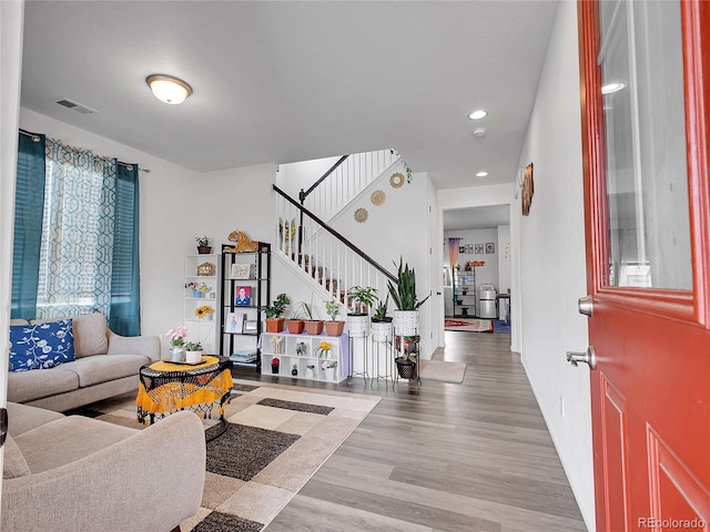 living area featuring recessed lighting, stairway, visible vents, and wood finished floors