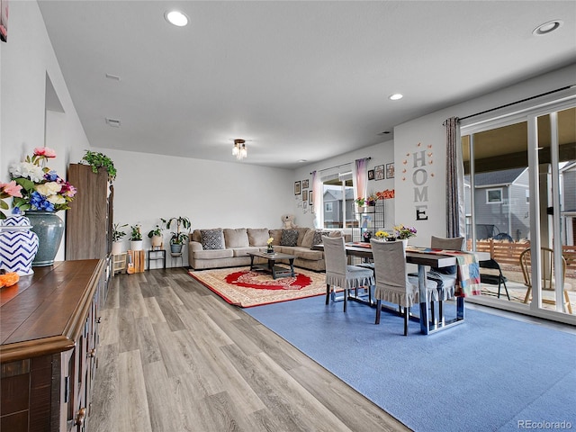 living room with recessed lighting, visible vents, and wood finished floors