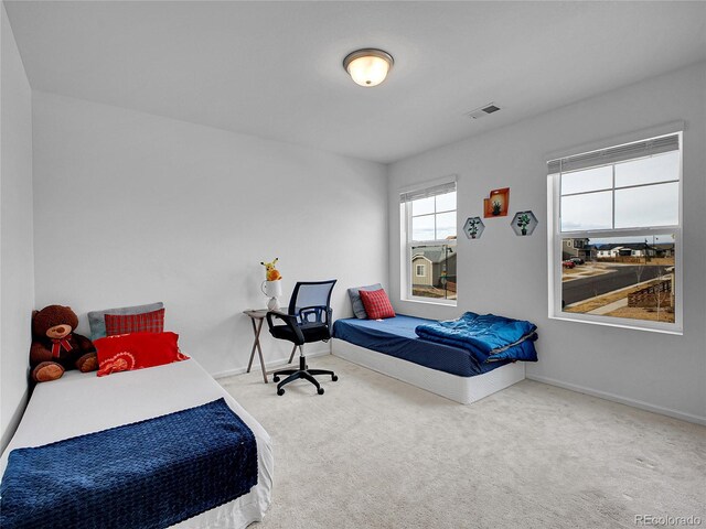 carpeted bedroom featuring visible vents and baseboards
