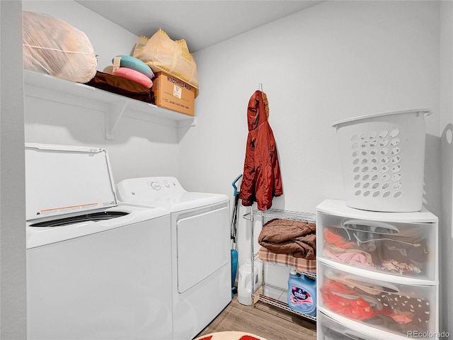 washroom with independent washer and dryer, wood finished floors, and laundry area