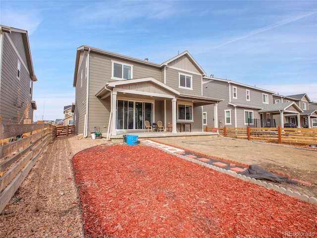 rear view of property with a patio, a fenced backyard, and board and batten siding
