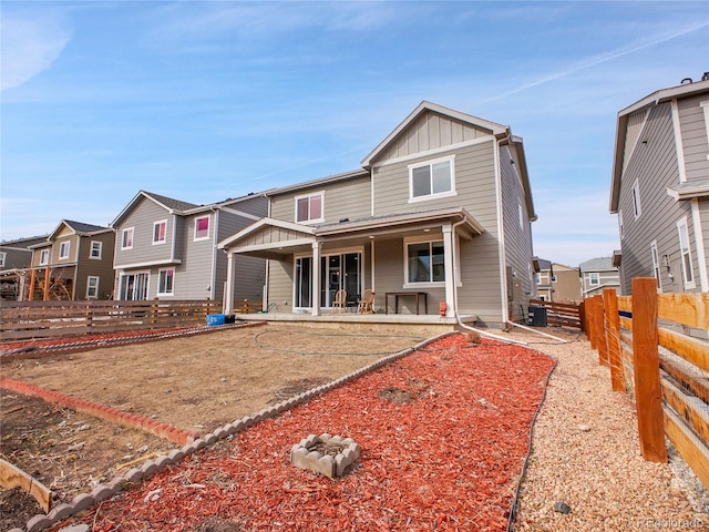 view of front of house with a patio area, central AC unit, board and batten siding, and a fenced backyard
