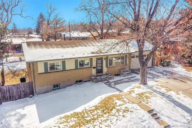 ranch-style home with a garage, concrete driveway, brick siding, and fence