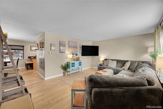 living area with light wood-type flooring and baseboards