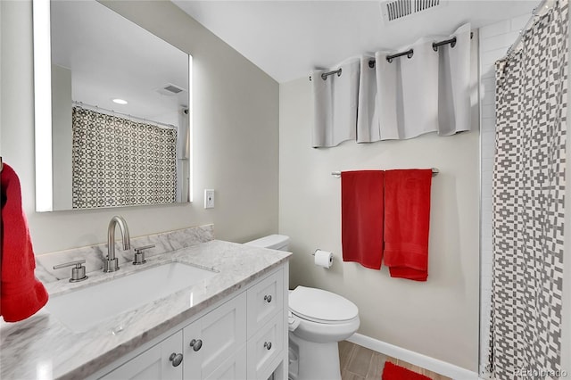 bathroom with vanity, visible vents, toilet, curtained shower, and baseboards
