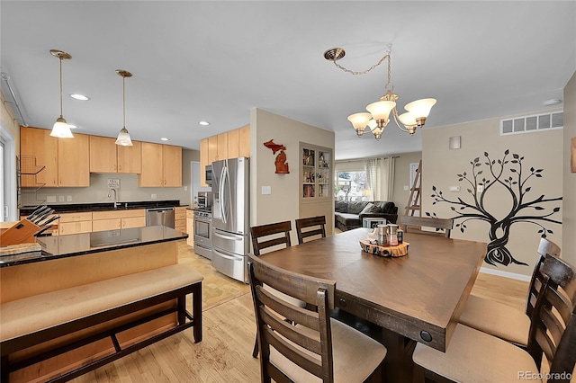 dining room with a chandelier, recessed lighting, light wood finished floors, and visible vents