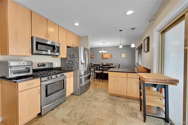 kitchen with dark countertops, a toaster, light brown cabinetry, and stainless steel appliances