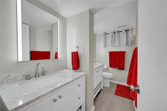 full bath with visible vents, baseboards, toilet, vanity, and wood finished floors