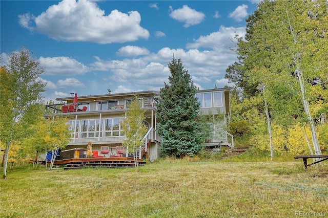 back of house with a lawn and a sunroom