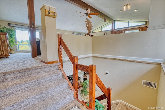 stairs with carpet floors, lofted ceiling with beams, and ceiling fan