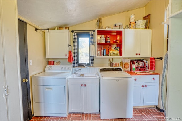 clothes washing area featuring separate washer and dryer and cabinets