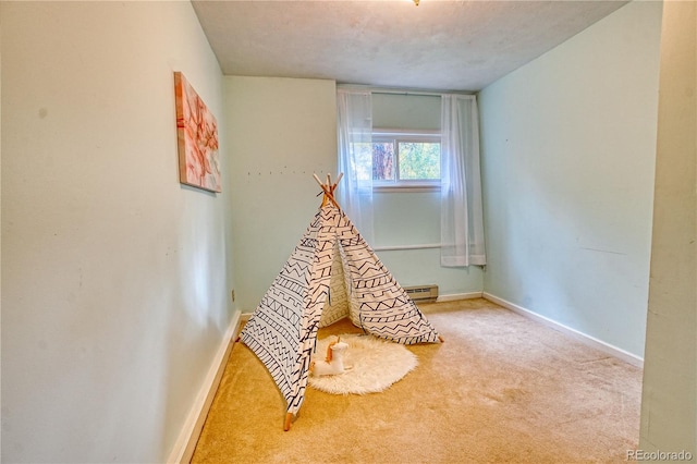 playroom featuring carpet floors, a textured ceiling, and baseboard heating