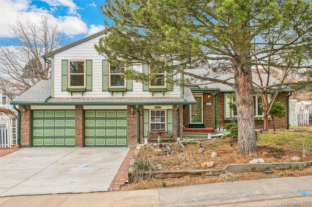 split level home featuring concrete driveway, a garage, brick siding, and a shingled roof