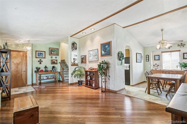 entryway with stairs, lofted ceiling, wood finished floors, a textured ceiling, and a ceiling fan