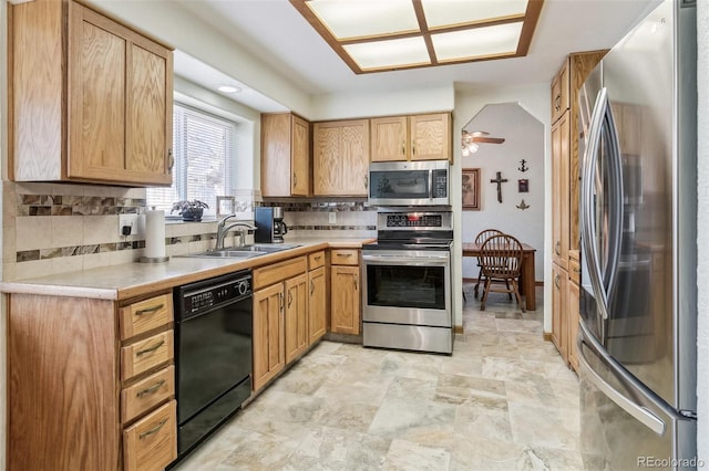 kitchen with a sink, stainless steel appliances, tasteful backsplash, and light countertops