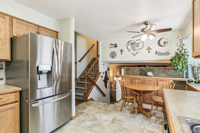 kitchen with a sink, light countertops, ceiling fan, and stainless steel fridge with ice dispenser