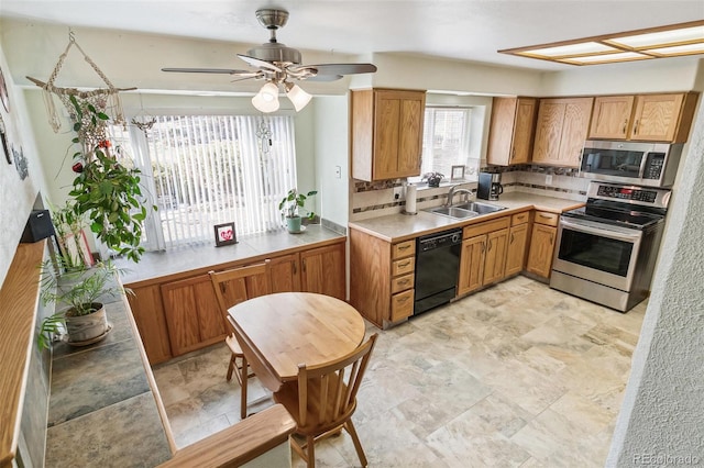 kitchen with a sink, decorative backsplash, ceiling fan, and stainless steel appliances