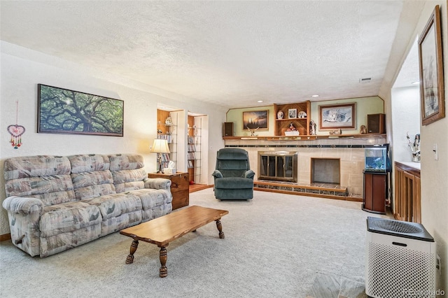 carpeted living area with a glass covered fireplace and a textured ceiling