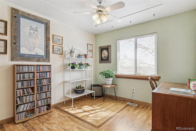 office space with visible vents, wood finished floors, baseboards, and ceiling fan