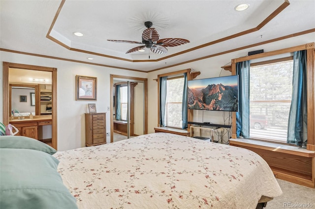 bedroom with multiple windows, crown molding, a raised ceiling, and ceiling fan