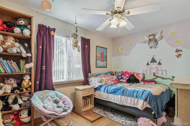 bedroom with a ceiling fan and a textured ceiling