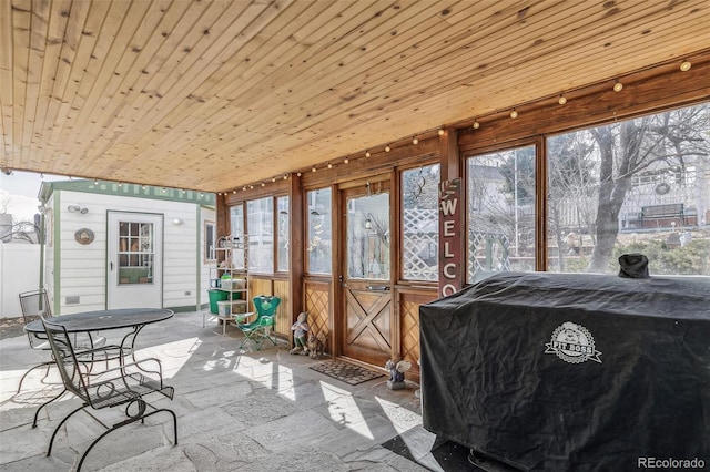 sunroom featuring wood ceiling and a healthy amount of sunlight