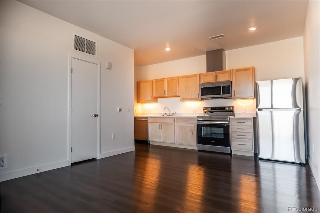 kitchen featuring stainless steel appliances, dark hardwood / wood-style flooring, sink, and light brown cabinets