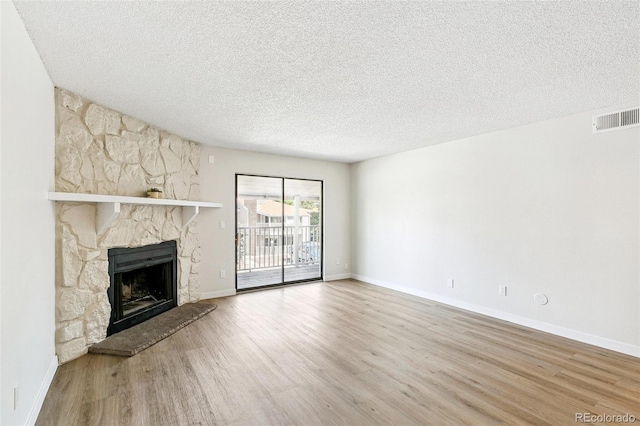 18302 E Kepner Pl Unit 207, Aurora, CO 80017 - unfurnished living room with a fireplace, wood finished floors, and a textured ceiling