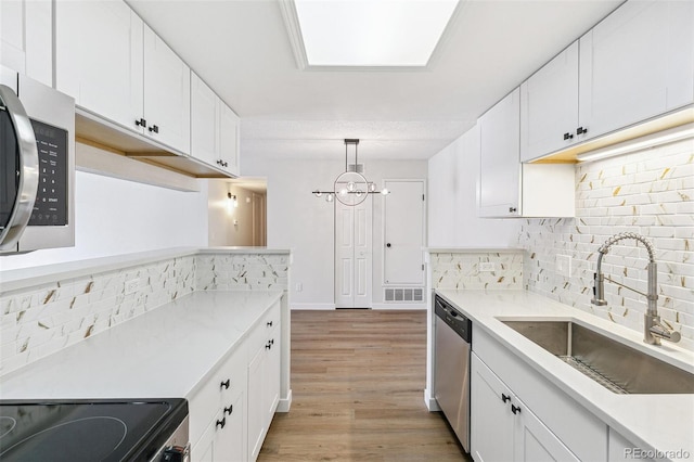 18302 E Kepner Pl Unit 207, Aurora, CO 80017 - kitchen with appliances with stainless steel finishes, decorative backsplash, light wood-style floors, and light countertops
