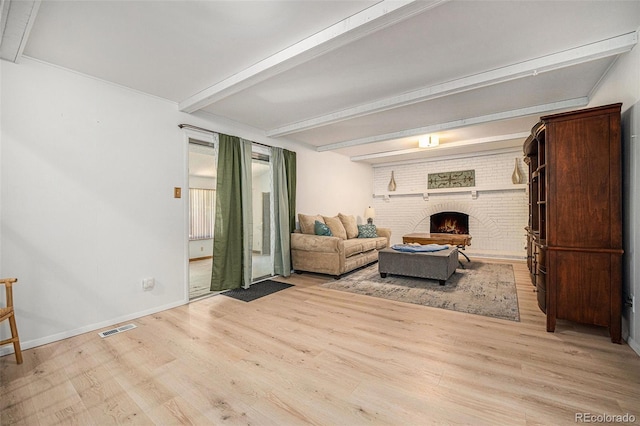 12289 W Atlantic Ave, Lakewood, CO 80228 - living room featuring wood finished floors, beam ceiling, a brick fireplace, and baseboards