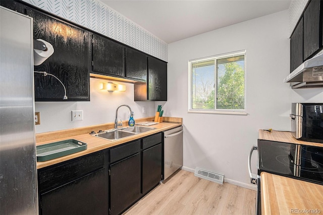 12289 W Atlantic Ave, Lakewood, CO 80228 - kitchen featuring a sink, stainless steel appliances, dark cabinetry, and light wood-type flooring