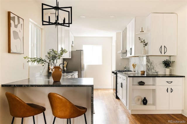 1219 Cherry St, Denver, CO 80220 - kitchen featuring open shelves, dark countertops, light wood finished floors, and stainless steel appliances