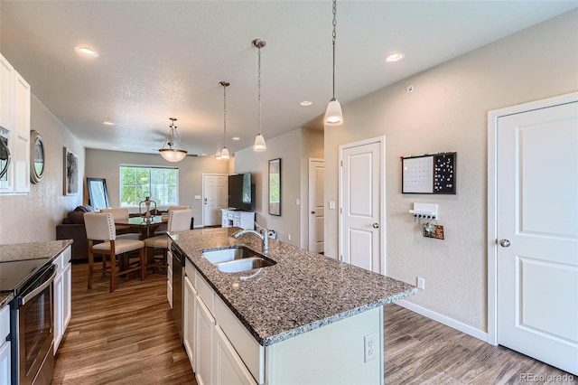 6024 W 1st St Unit 30, Greeley, CO 80634 - kitchen with a sink, wood finished floors, open floor plan, white cabinets, and recessed lighting