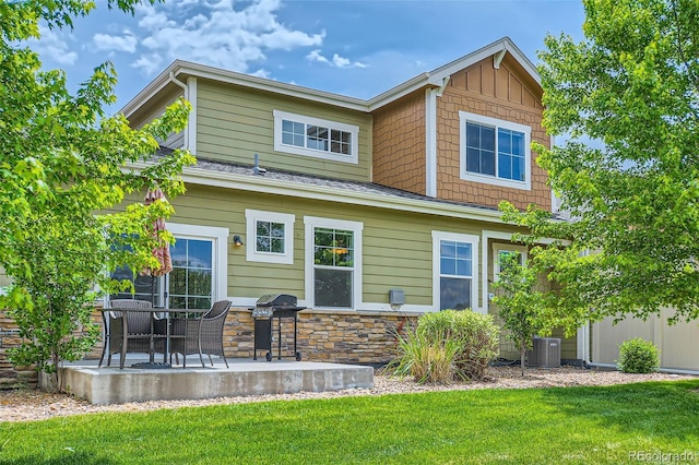 6024 W 1st St Unit 30, Greeley, CO 80634 - back of property featuring cooling unit, a patio, a yard, stone siding, and a shingled roof