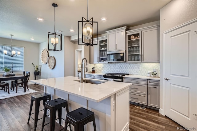 13460 Broad Wing Ave, Parker, CO 80134 - kitchen with appliances with stainless steel finishes, a sink, a chandelier, gray cabinetry, and decorative backsplash