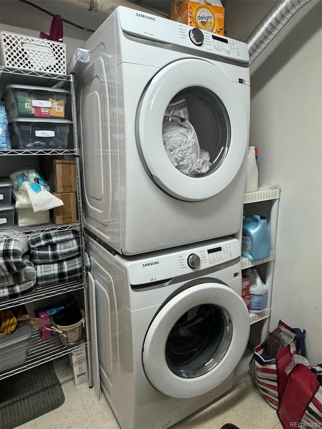 clothes washing area featuring stacked washer / dryer and laundry area