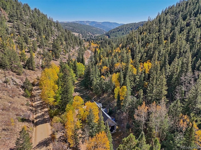 birds eye view of property with a wooded view and a mountain view