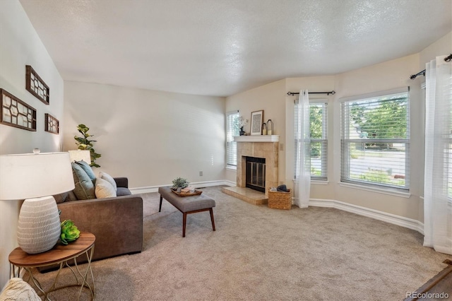 carpeted living room with a textured ceiling and a fireplace