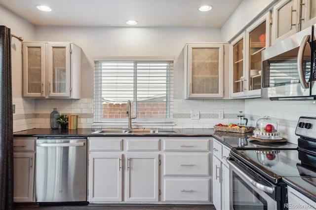 kitchen with white cabinets, backsplash, sink, and appliances with stainless steel finishes